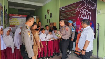 Kapolsek NA IX-X Bagikan Buku ke Siswa Sekolah Dasar di Kampung Pajak